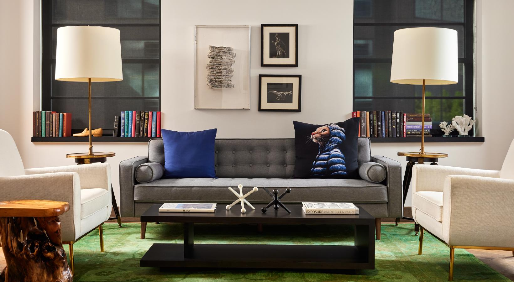 a living room with a couch coffee table lamps and windows
