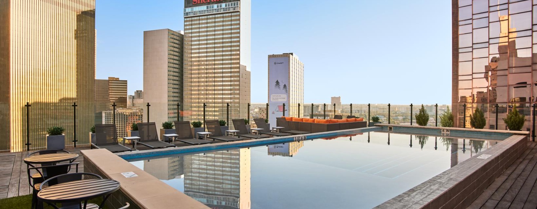 a pool with a deck and tall buildings in the background